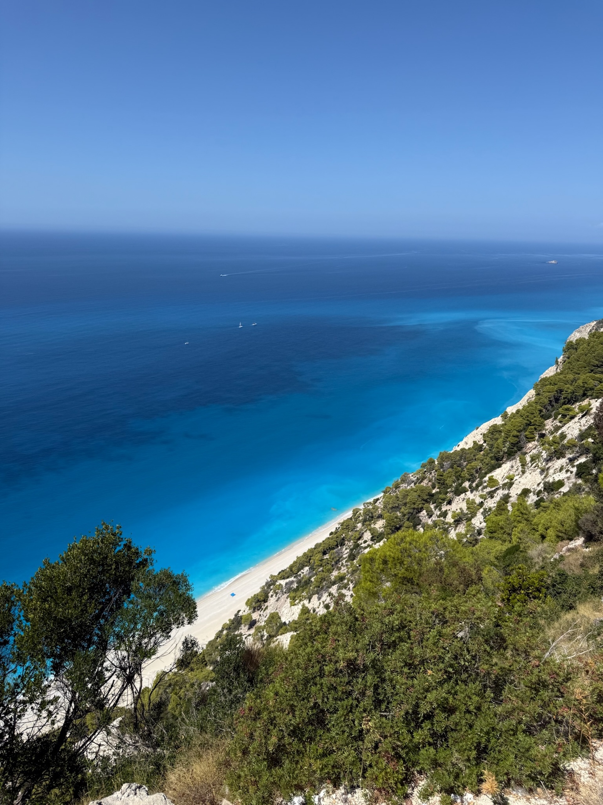 Egremni beach from above — white cliffs, pine forests, and the electric blue Ionian Sea