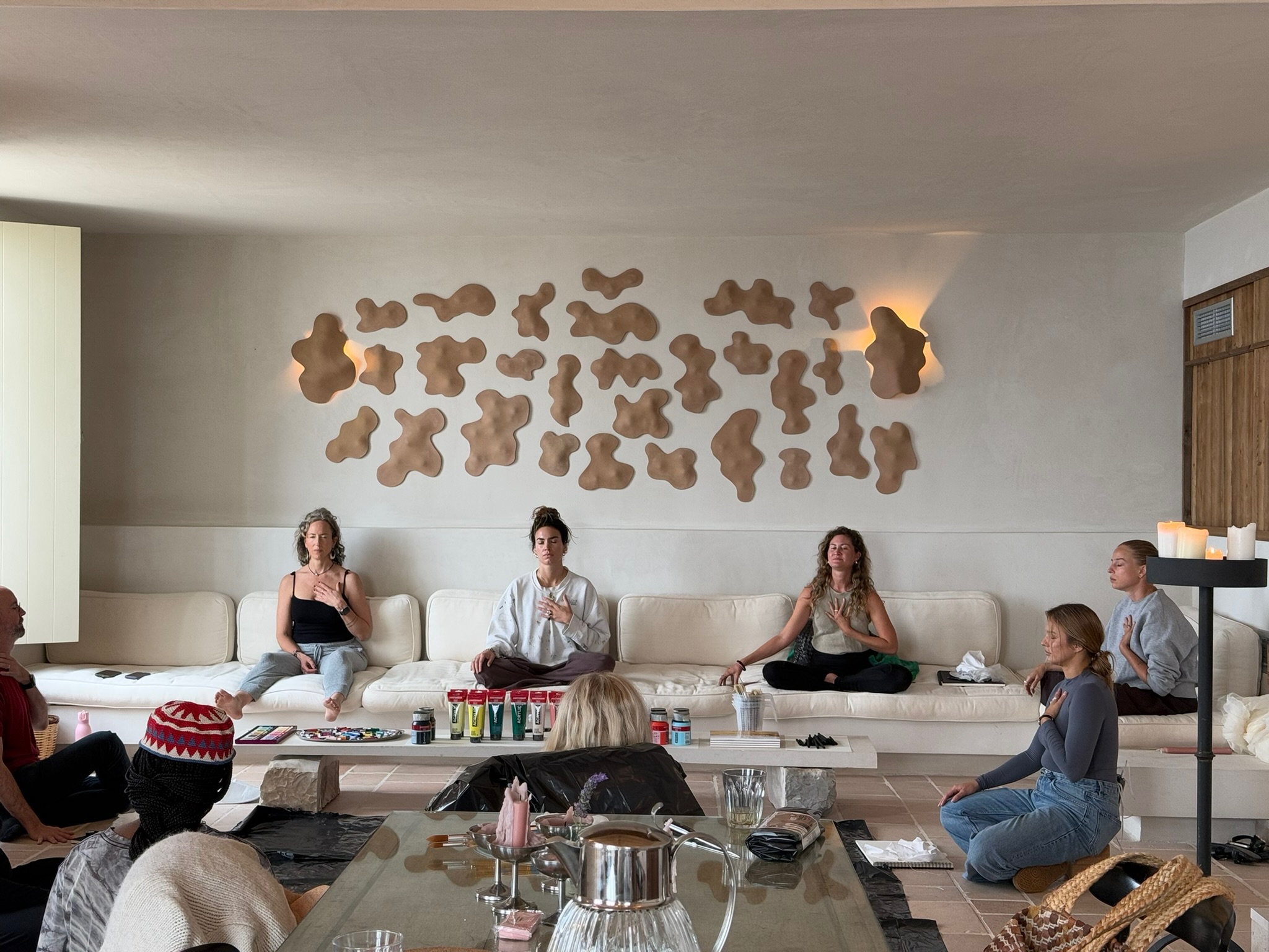 Morning practice in the villa — hands on heart, candlelight, the small ceremony of arrival